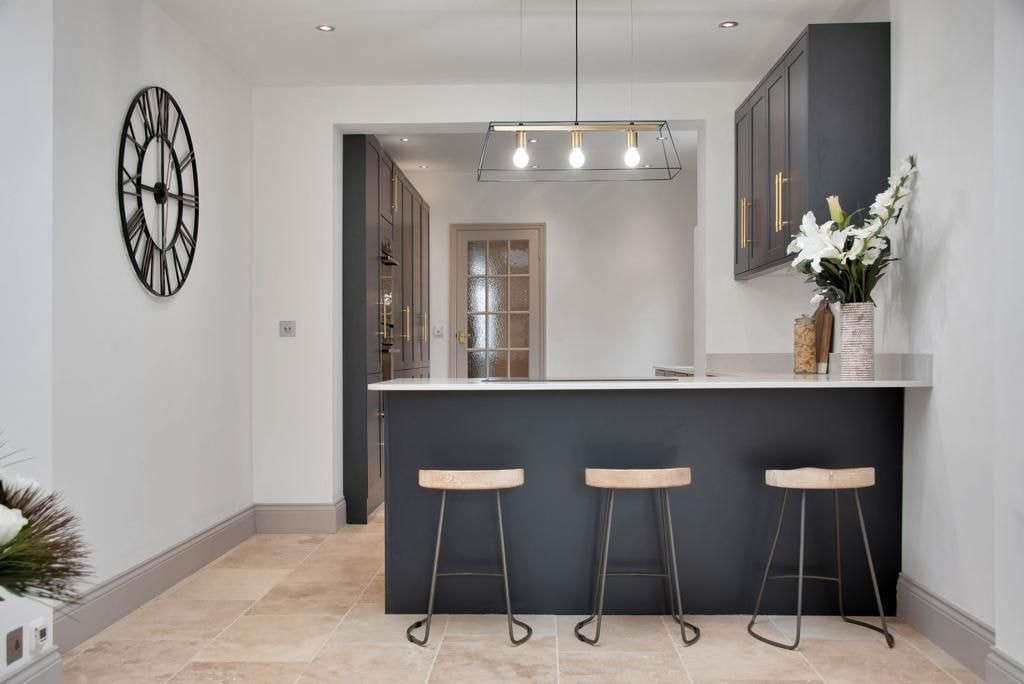 Bespoke dark shaker kitchen with peninsula and bar stools in Cambridge by Cromwell Interiors