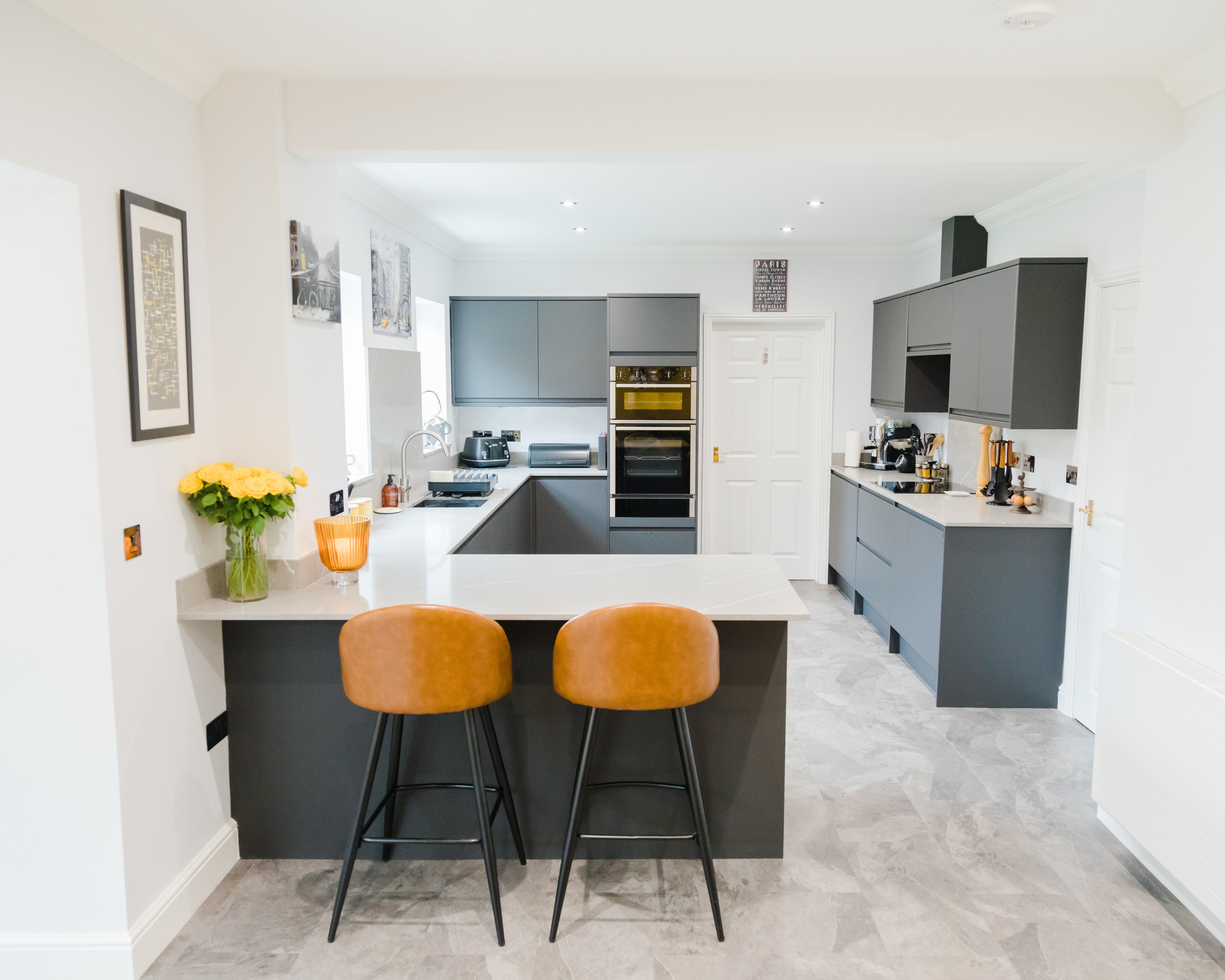 Bespoke graphite handleless kitchen with leather bar stools in Saffron Walden by Cromwell Interiors