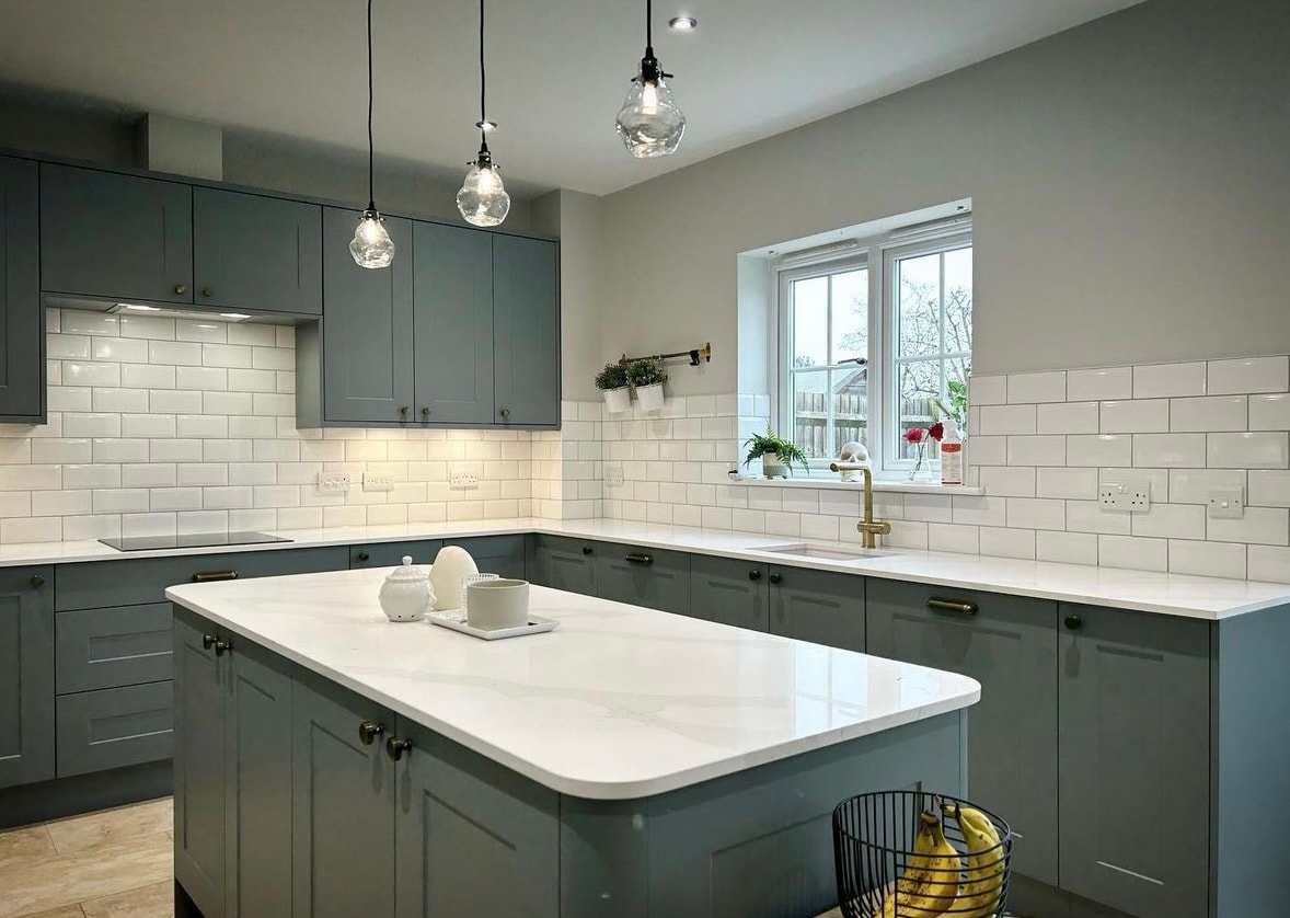 Bespoke sage green kitchen with subway tiles and marble island in Newmarket by Cromwell Interiors