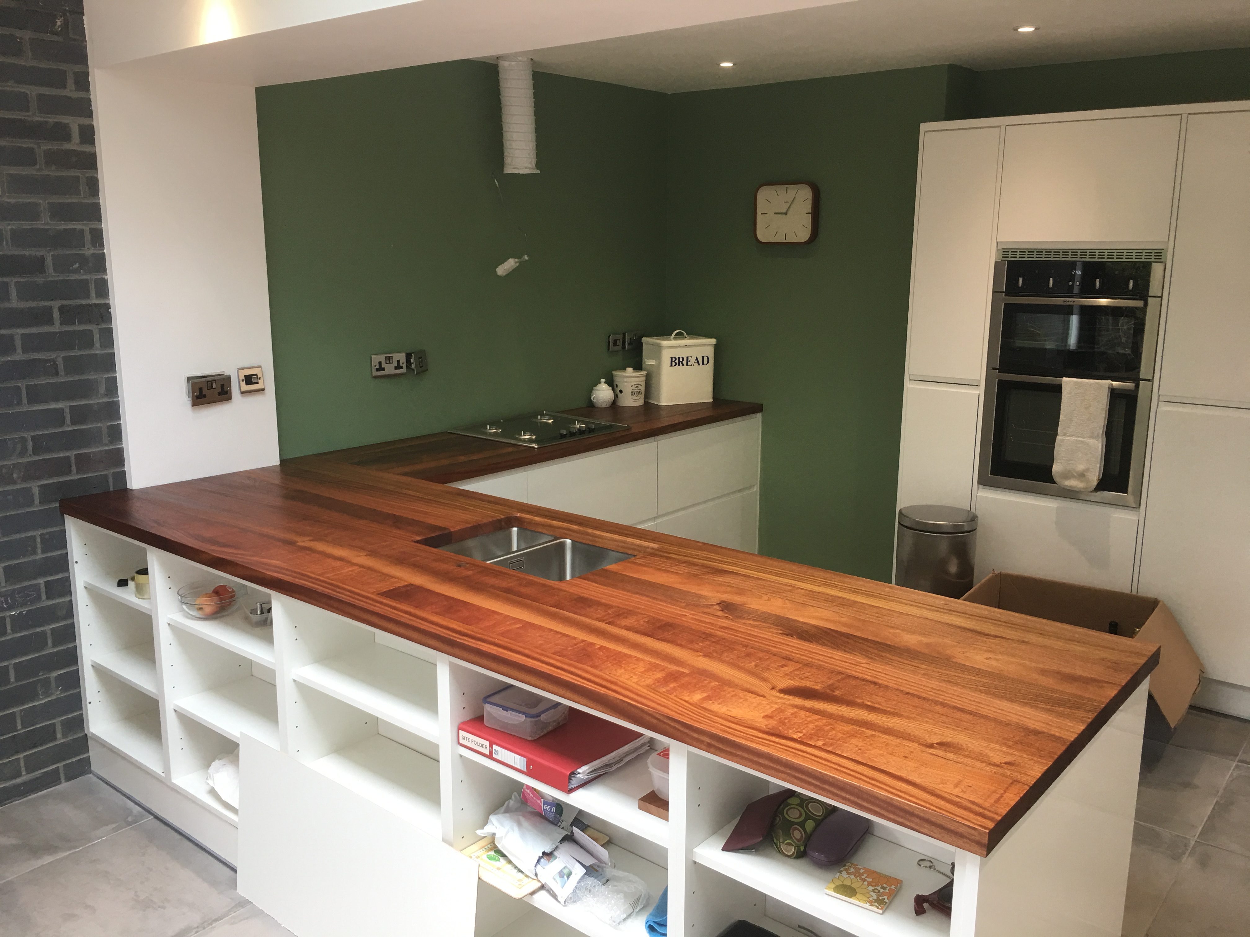 Bespoke kitchen with solid wood island and green feature wall in Cambridge by Cromwell Interiors