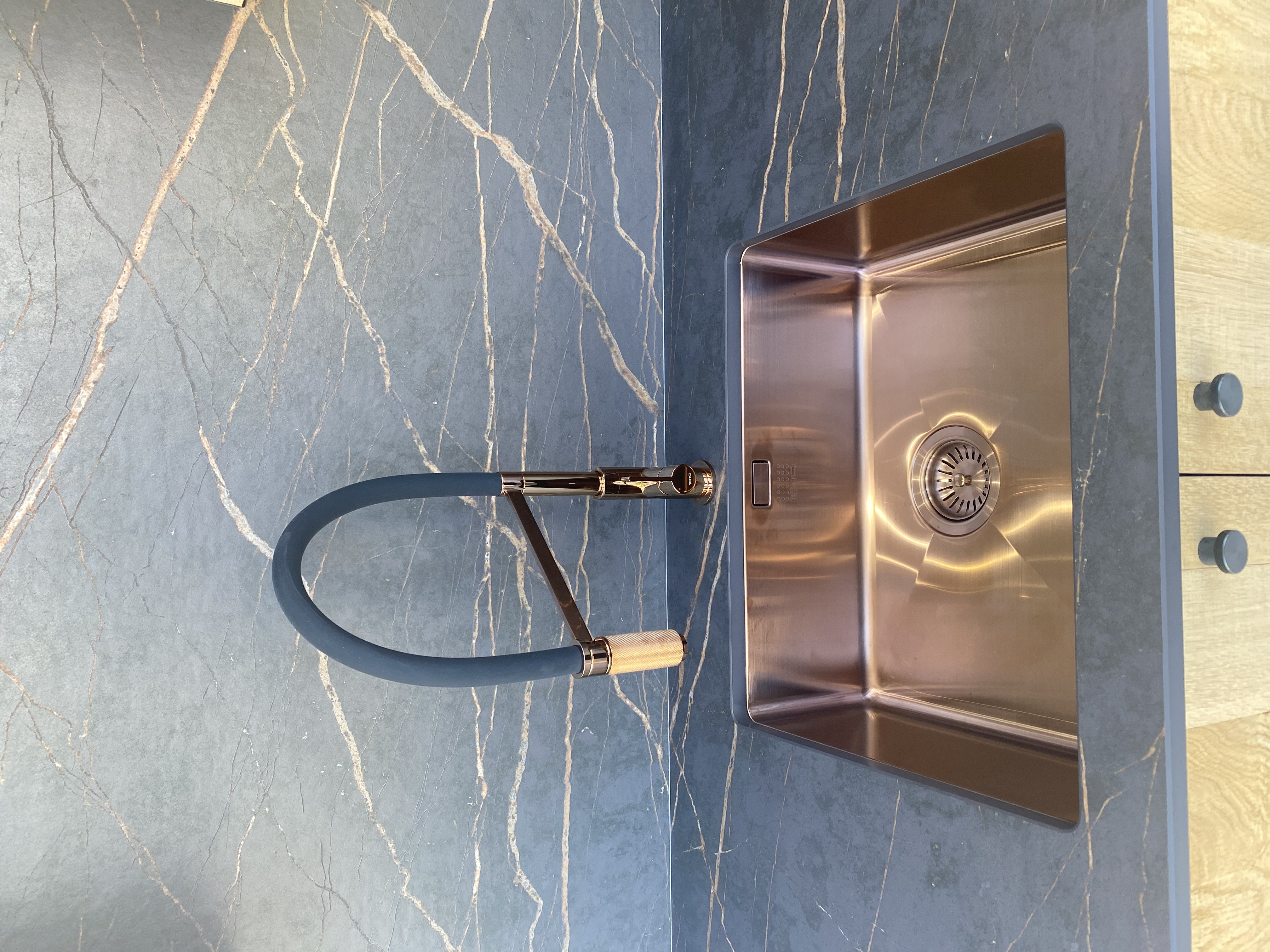 Bespoke kitchen sink detail with copper tap and marble worktop in Saffron Walden by Cromwell Interiors